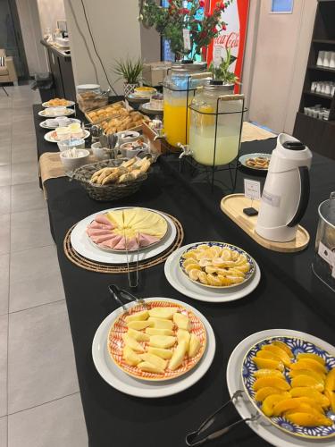 ピラルにあるPilar Suites by Vivaの長い黒いテーブルに盛り付けられた料理