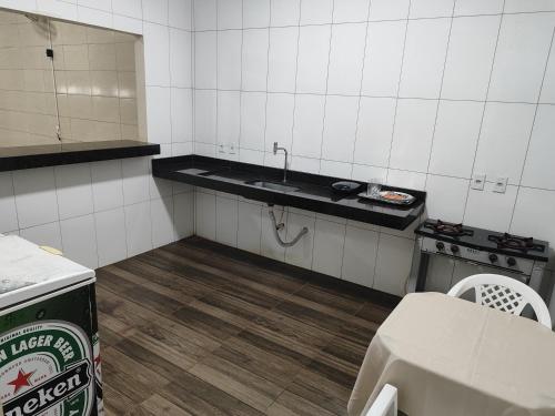 Una pequeña cocina con fregadero y estufa. en Aluguel de um quarto - Espaço Maranata, en Porangatu