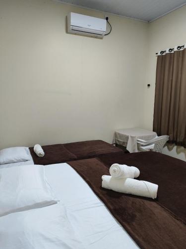 a bedroom with two white towels on a bed at Aluguel de um quarto - Espaço Maranata in Porangatu