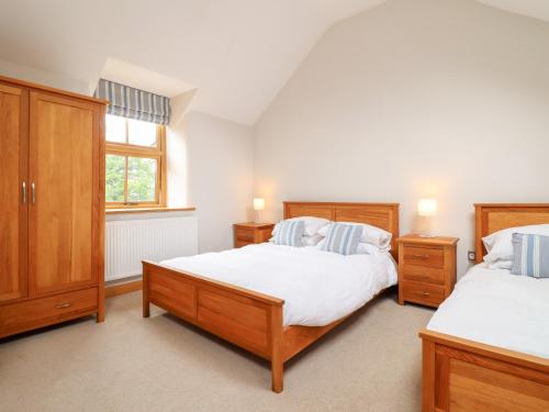 une chambre avec deux lits et une fenêtre dans l'établissement Ty Gwyn, à Llangwm