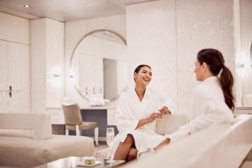 a woman laughing while sitting in a bathroom mirror at The Ritz-Carlton, Grand Cayman in George Town
