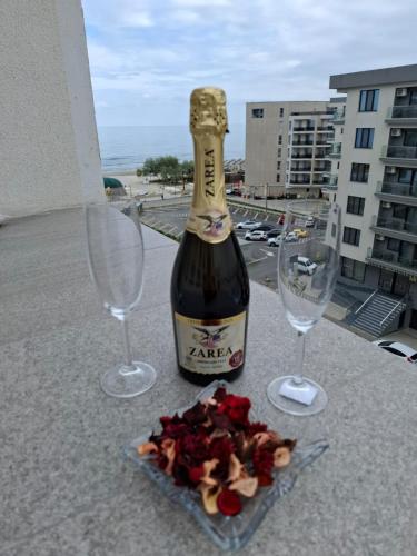 a bottle of wine and two glasses on a balcony at RUXO Hotel in Mamaia Nord