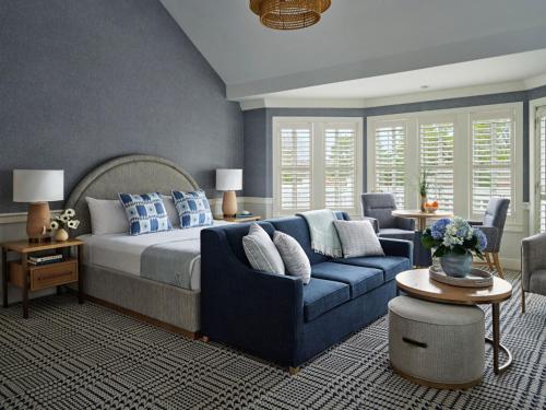 a bedroom with a blue bed and a blue couch at Wequassett Resort and Golf Club in East Harwich