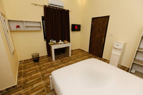 a bedroom with a white bed and a desk and a window at Turquoise Pyramids Gate Hotel City Centre in Cairo
