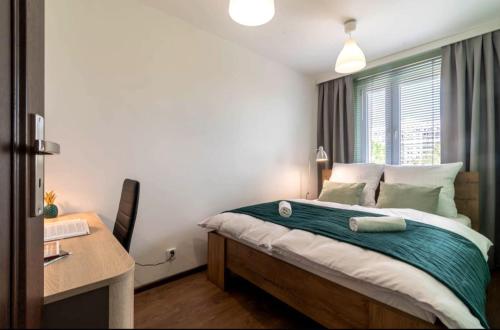 a bedroom with a bed and a desk and a table at Stablewskiego Poznań Spot in Poznań