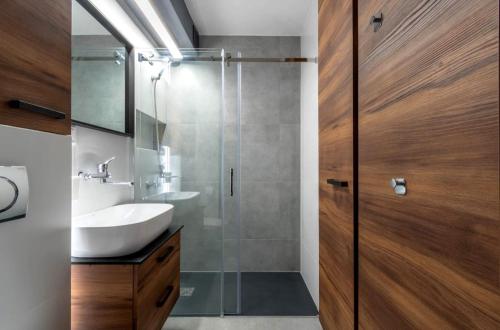 a bathroom with a sink and a glass shower door at Stablewskiego Poznań Spot in Poznań