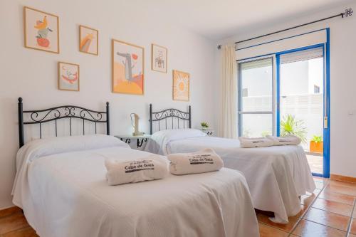 three white beds in a room with a window at Casa Dracaena in San José
