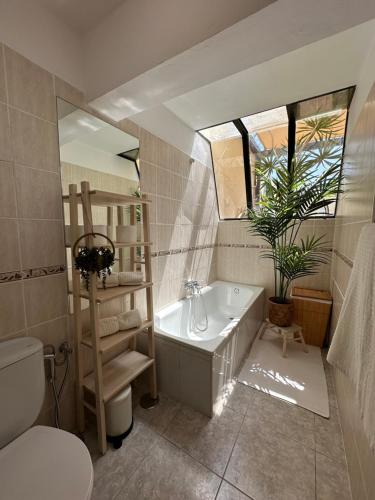 Un baño con bañera, inodoro y lavabo. en La Casita del Tío Juan, en Morro del Jable