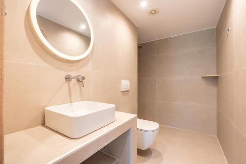 a bathroom with a white sink and a mirror at CrossRhodes Villas in Pefki Rhodes