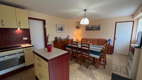 une cuisine et une salle à manger avec une table et des chaises dans l'établissement Appartemet en rez de jardin Au Clos du Golfe, à Locmariaquer