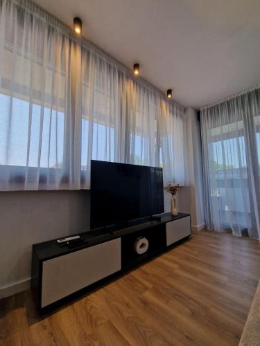 a living room with a flat screen tv in front of windows at District 21 in Belgrade
