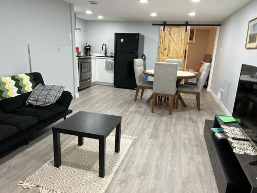 a living room with a black couch and a table at Gorgeous Basement Apartment in Calgary