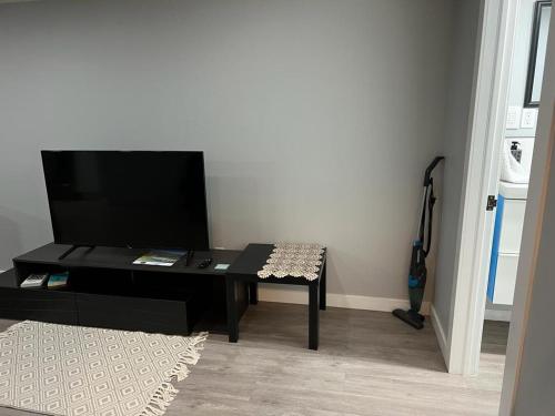 a living room with a table and a television at Gorgeous Basement Apartment in Calgary