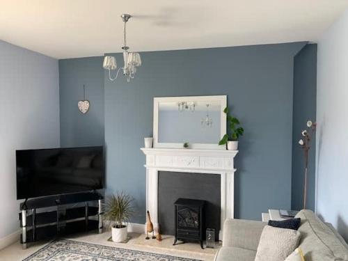 a living room with blue walls and a fireplace at New Road Hideaway in Newton