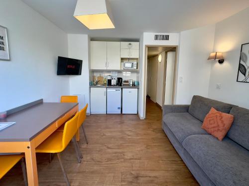 un salon avec un canapé et une table dans l'établissement Le Clemenceau - SCLS Locations, à Cannes