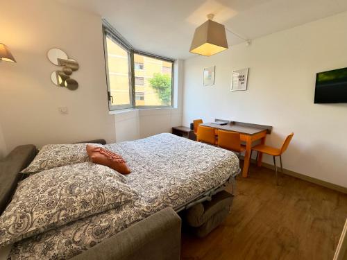 une chambre avec un lit, une table et un bureau dans l'établissement Le Clemenceau - SCLS Locations, à Cannes