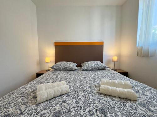 une chambre avec un lit avec deux oreillers dessus dans l'établissement Le Clemenceau - SCLS Locations, à Cannes
