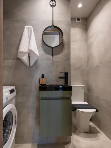 a bathroom with a sink and a washing machine at Ergina Apartments Gournes Studio & Family Apartment in Gournes
