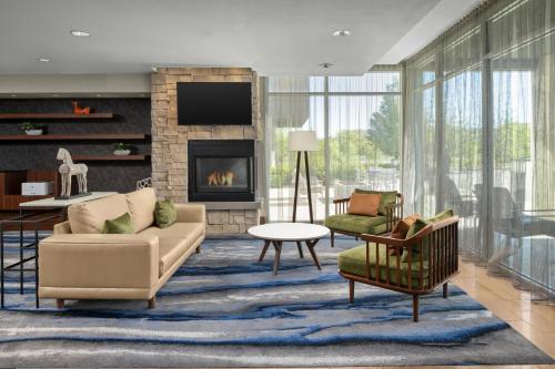 ミッドベールにあるFairfield Inn & Suites by Marriott Salt Lake City Midvaleのソファと椅子と暖炉のあるリビングルーム