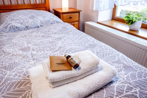 a bottle on a towel with a book on a bed at Pension U Lípy in Rovečné
