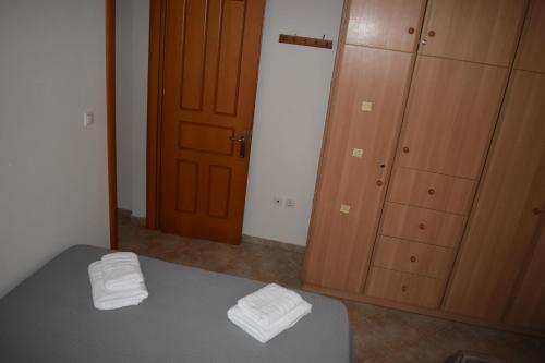a bedroom with a bed and a closet with two towels at Under the pine tree in Divarata