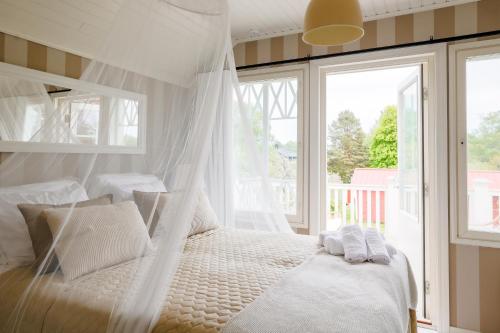 een slaapkamer met een bed met witte kussens en een raam bij Villa Ankkuri in Hanko