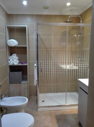 a bathroom with a shower and a toilet and a sink at Casa São José in Caminha