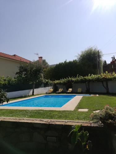 a swimming pool in a yard with two chairs at Casa São José in Caminha