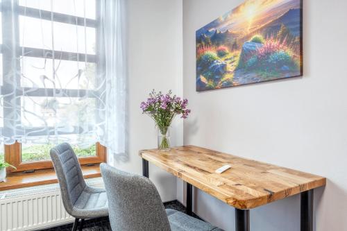 a dining room with a wooden table and two chairs at Pension U Lípy in Rovečné