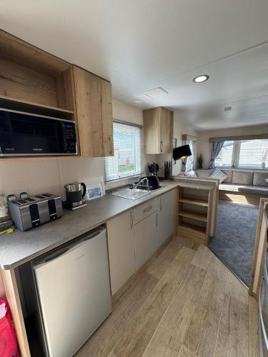 a kitchen with a sink and a counter top at Fantasy Island - Eastgate D7 - The Merlin with Hot Tub - Coastal Caravan Breaks in Ingoldmells