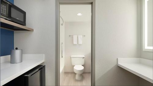 a bathroom with a toilet and a glass door at Holiday Inn Express Dallas Market Center by IHG in Dallas