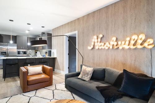 a living room with a couch and a kitchen at The Odyssey Apartments by AvantStay in Nashville