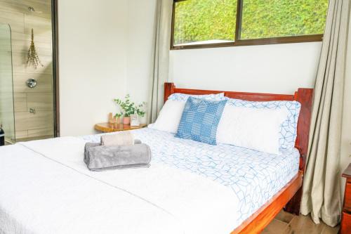 a bedroom with a white bed with a window at Canavida Villas & Resort in Uvita