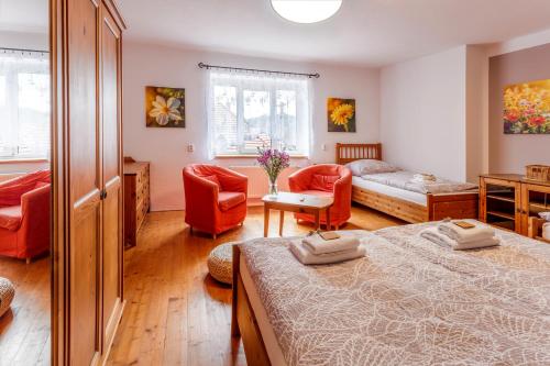 a bedroom with two beds and a couch and chairs at Pension U Lípy in Rovečné