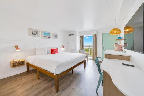 a hotel room with a bed and a desk and a room at Madison Resort Wildwood Crest in Wildwood Crest