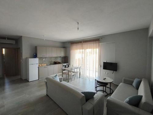 a living room with a couch and a table and a kitchen at Irina's Apartment 3 in Psakoudia