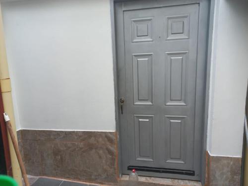 a gray door on the side of a building at Alojamiento Betina in Salamina