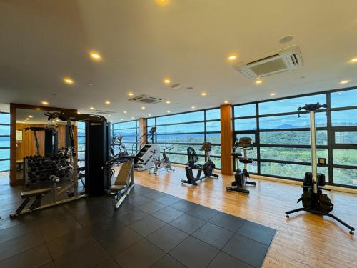 a gym with cardio equipment in a large room with windows at Malibu Langkawi Private Pool Villa in Pantai Cenang