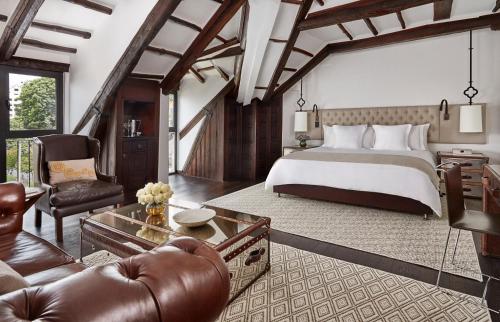 a bedroom with a large bed and a living room at Four Seasons Hotel Casa Medina Bogota in Bogotá