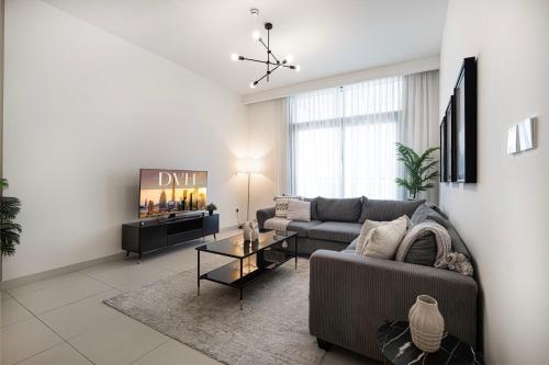 a living room with a couch and a tv at Burj Crown Luxury 4 Bedroom, Balcony Views, 5 min to Burj Khalifa in Dubai