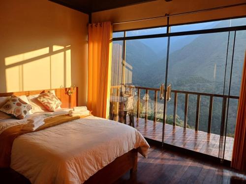 una camera da letto con un letto e una grande finestra di Ecoterra Inka Lodge a Quillabamba
