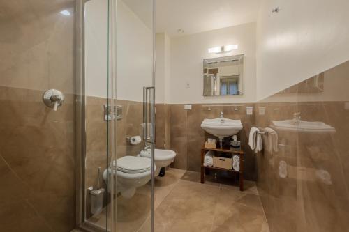 a bathroom with a toilet and a sink and a shower at Hotel Bartolomeo in Venice