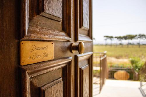 a wooden door with a sign on it with a view of a field at Casa Baí in Torre Nubia