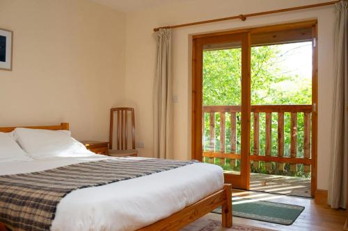 a bedroom with a bed and a sliding glass door at Robins Perch Eco Lodge Apartment Lampeter in Lampeter