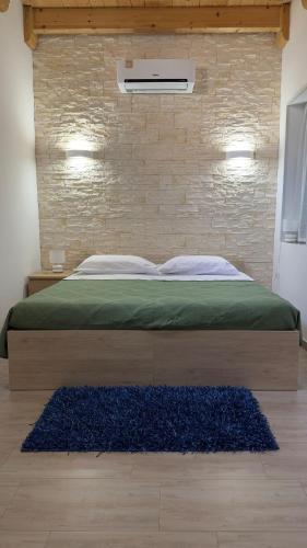 a bed in a bedroom with a brick wall at Copernico casa vacanze, nel centro di Lecce in Lecce