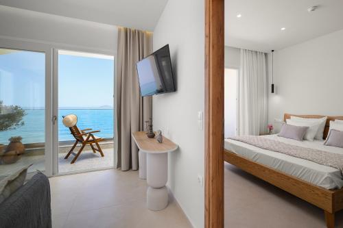 a bedroom with a bed and a tv on a wall at Pelagos Home in Kalamaki Heraklion