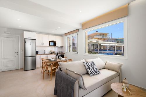 a living room with a couch and a kitchen at Pelagos Home in Kalamaki Heraklion