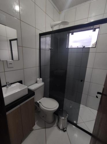 a bathroom with a toilet and a sink and a window at Hotel Pousada Vale Das Águas in Capinzal
