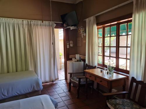 Una habitación de hotel con una cama, un escritorio y una mesa. en Lourie Inn, en Rustenburg
