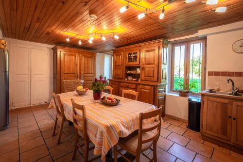 une cuisine avec une table et des chaises dans une pièce dans l'établissement Charmante Maison dans les Gorges de la Sioule, à Chouvigny